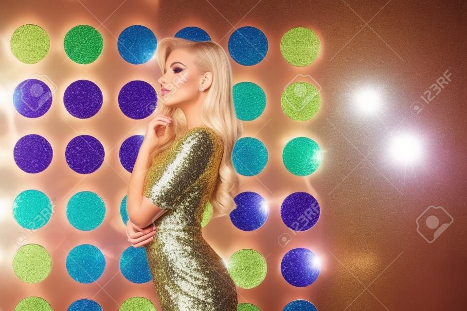 beautiful luxurious blonde woman in elegant sequin dress posing. copy space for text