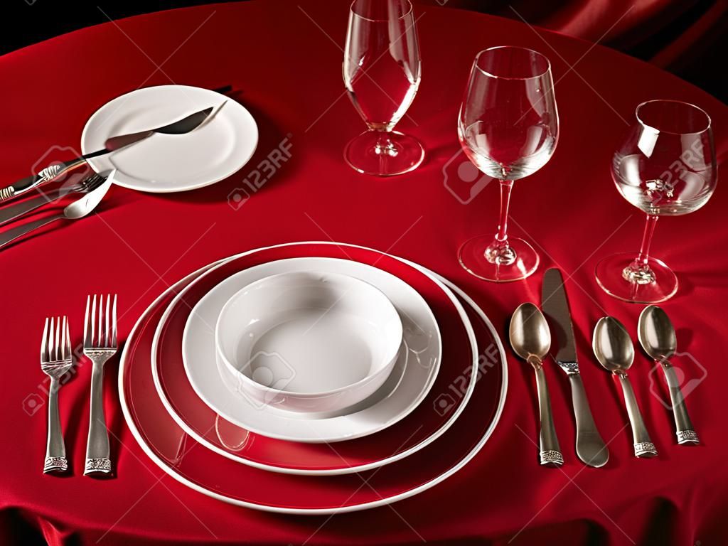 Red table with dinner set. Professional banquet table setting