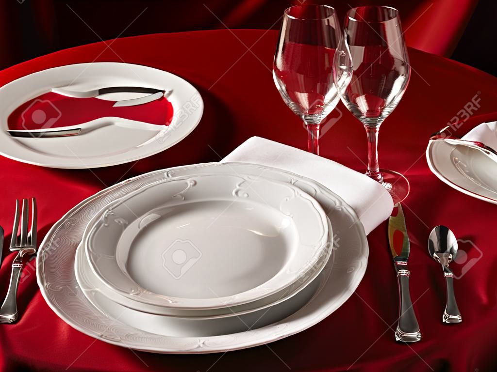 Red table with dinner set. Professional banquet table setting