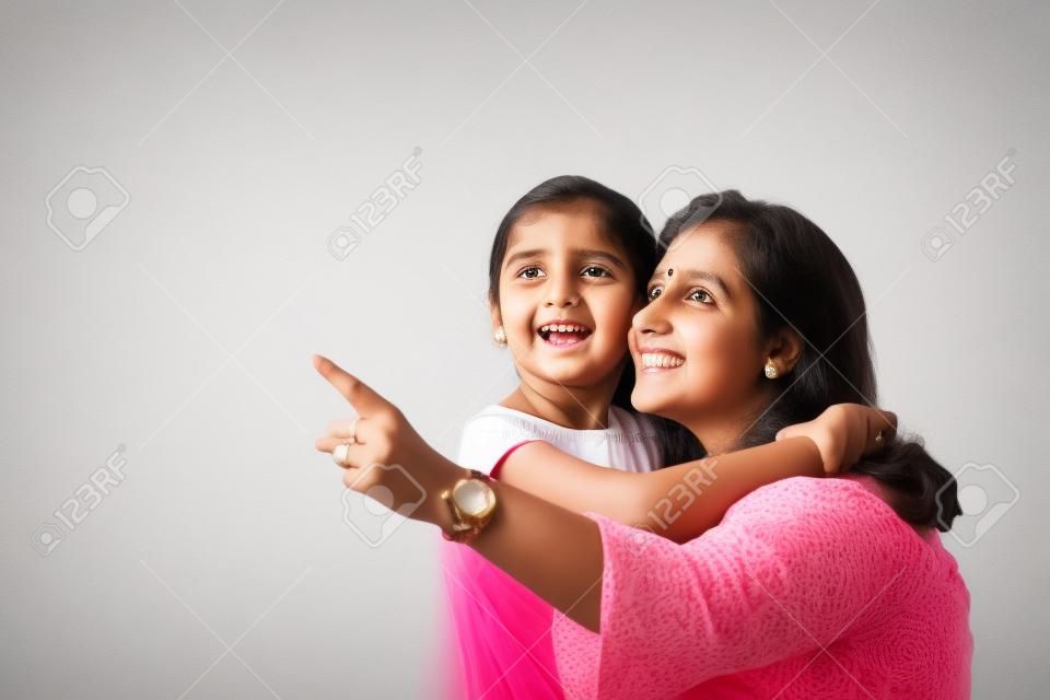 Indyjska matka córka na białym tle przytulająca, całująca, ujeżdżająca, latająca, wskazująca, prezentująca na białym tle