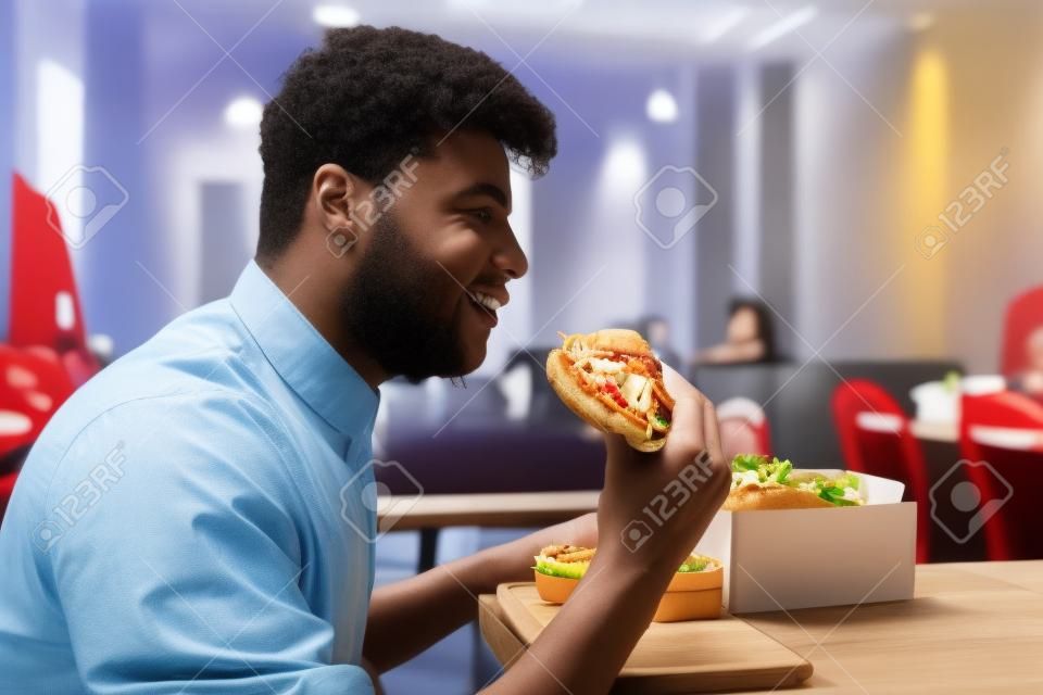 Studen está comendo em um quarto e desfrutando de fast food