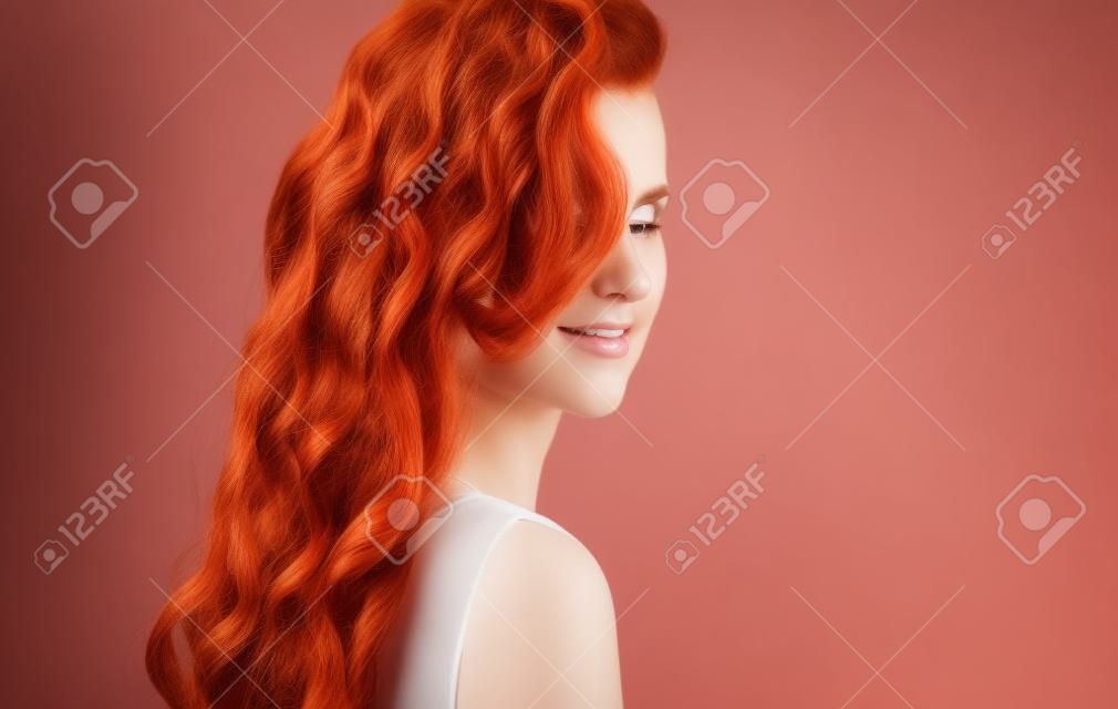schöne junge Frau mit lockigen roten Haaren. Schönheitsporträt des gesunden Haarmädchens