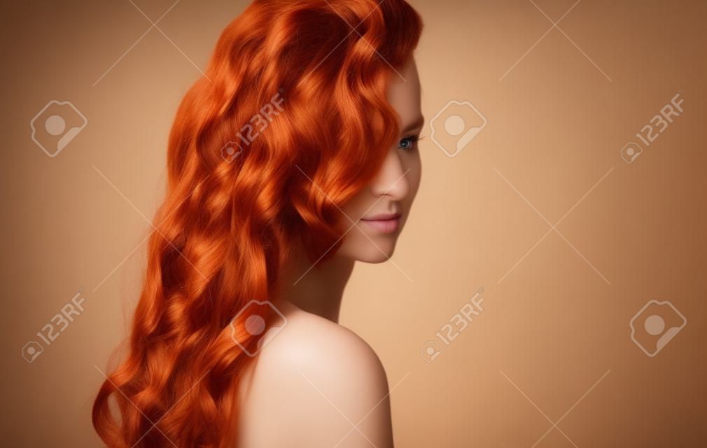 schöne junge Frau mit lockigen roten Haaren. Schönheitsporträt des gesunden Haarmädchens