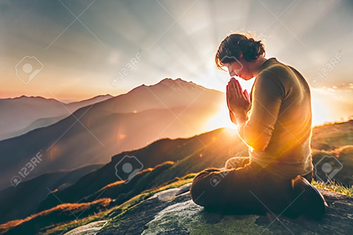 Man bidden op zonsondergang bergen Travel Lifestyle spirituele ontspanning emotionele concept vakanties buiten harmonie met natuur landschap