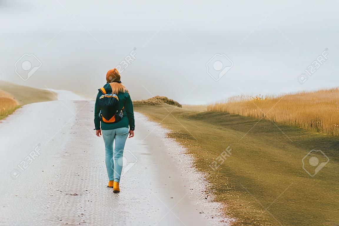 Tourist woman walking alone outdoor Travel Lifestyle wanderlust concept foggy nature adventure active vacations