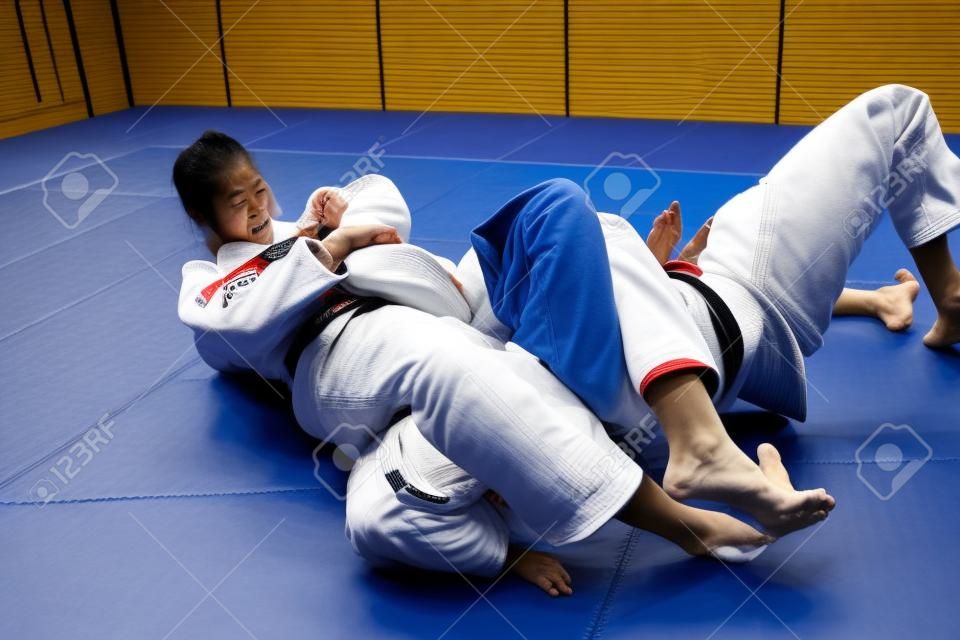 Zwei Frauen kämpfen auf Tatami. Judo, Jiu Jitsu