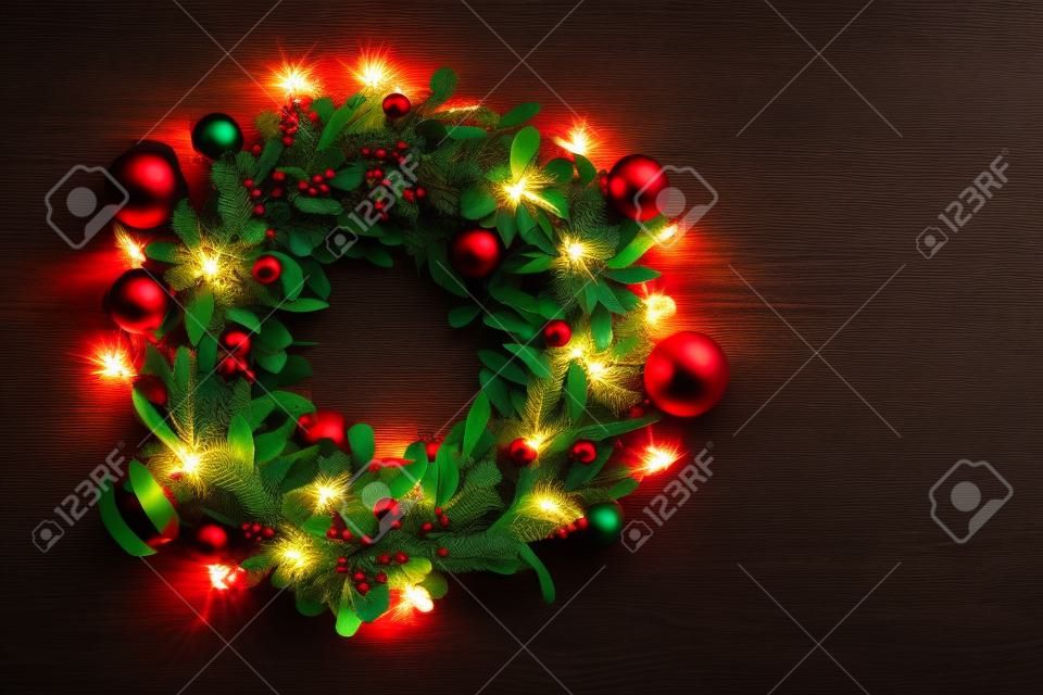 Concept de saison de salutation. Couronne de Noël avec lumière décorative sur fond de bois sombre