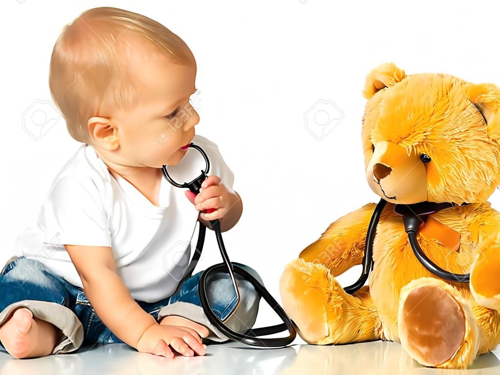 bebé juega en el médico oso de juguete y un estetoscopio