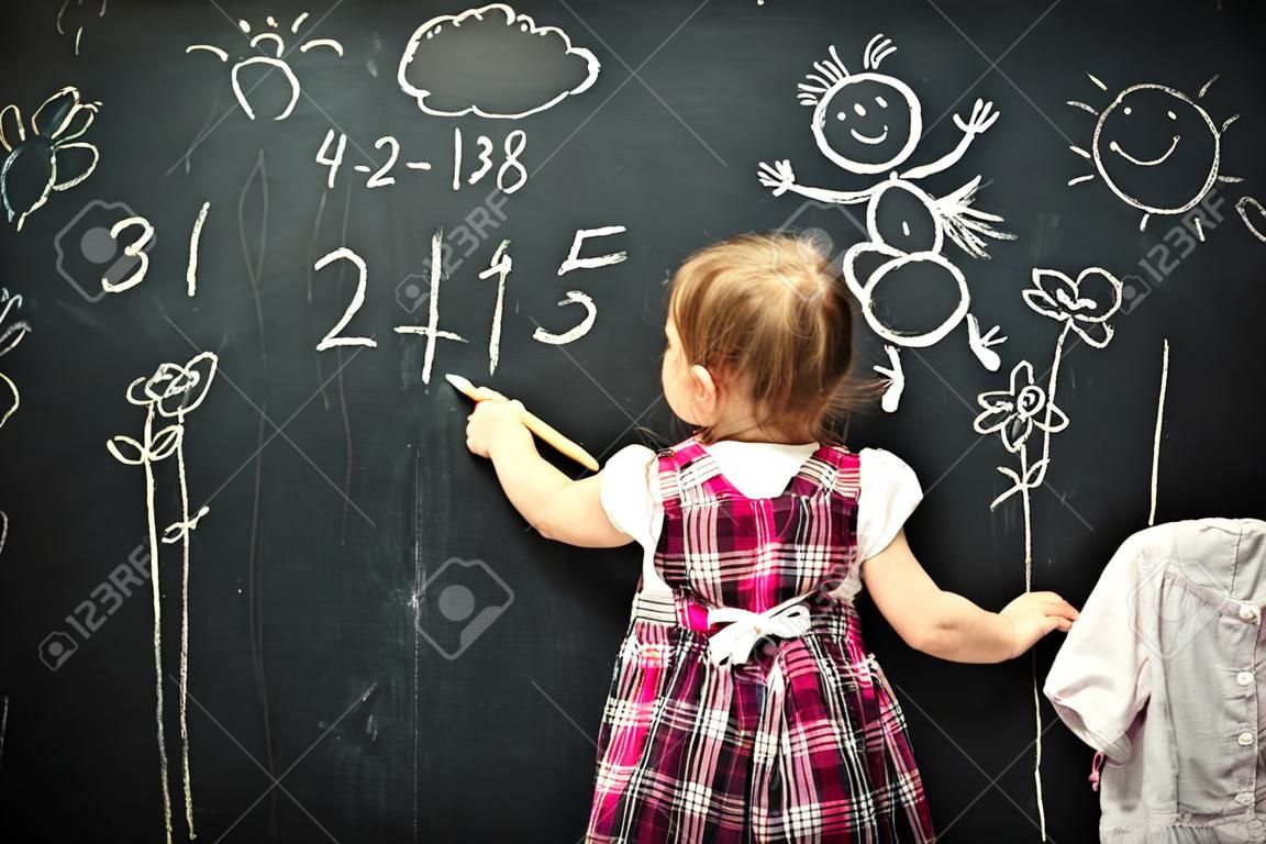 女嬰的學生繪製的粉筆在黑板上