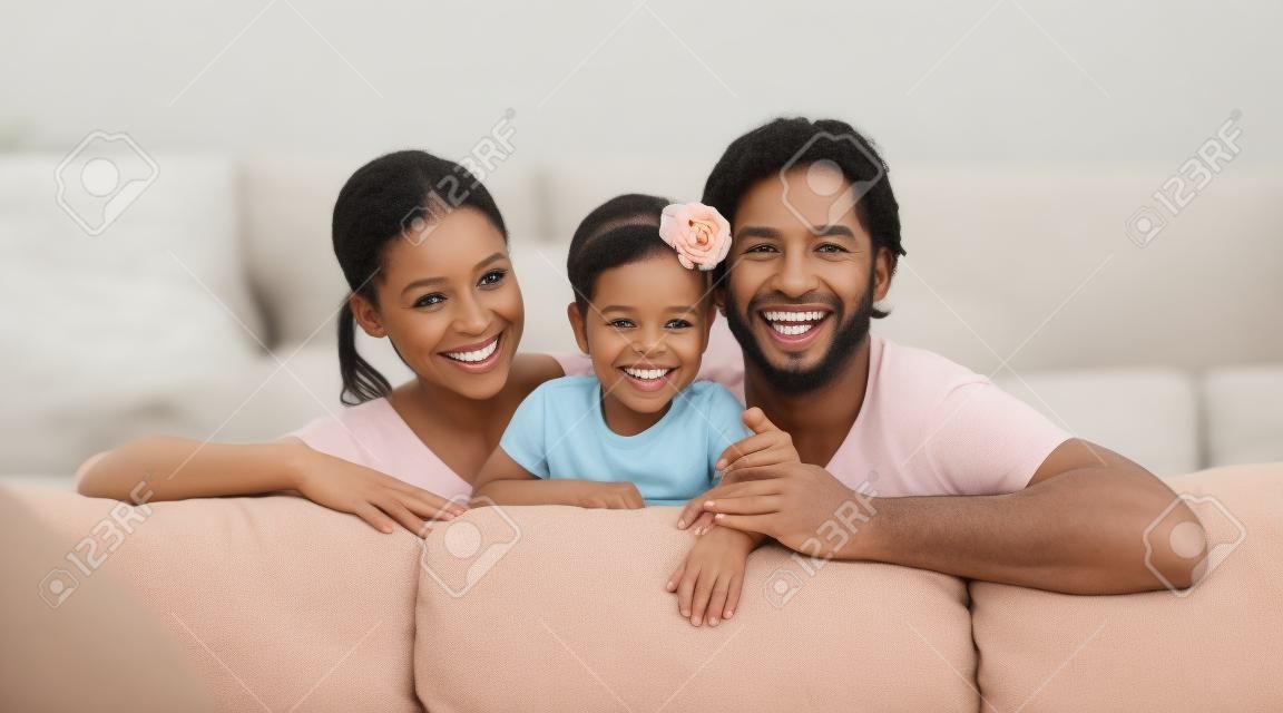 Gelukkige familie moeder, vader, kind baby dochter thuis op de bank spelen en lachen