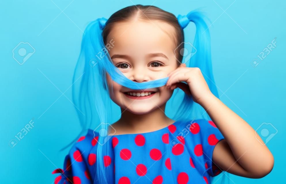 visage heureux fille drôle enfant dans une robe bleue