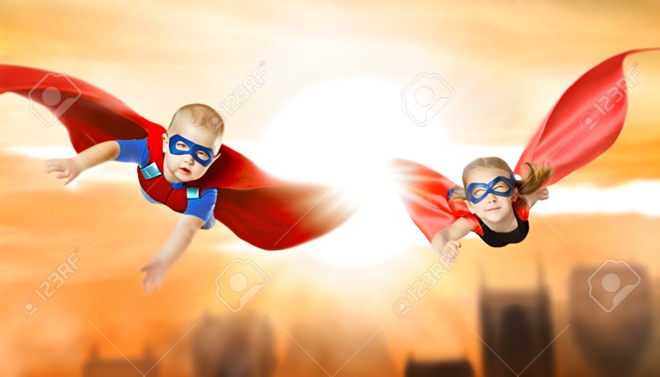 enfants super-héros volant à travers le coucher du soleil ciel. garçon et fille frère et soeur