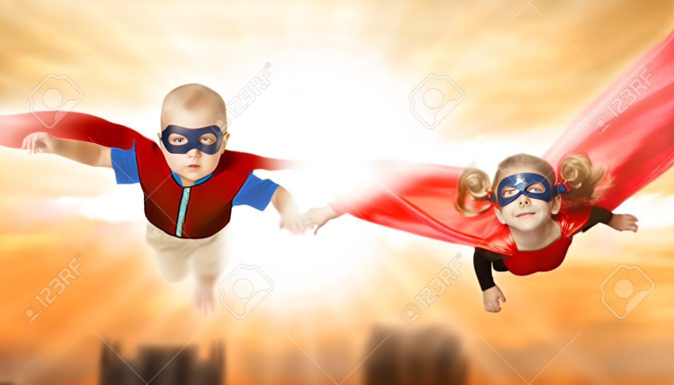 enfants super-héros volant à travers le coucher du soleil ciel. garçon et fille frère et soeur