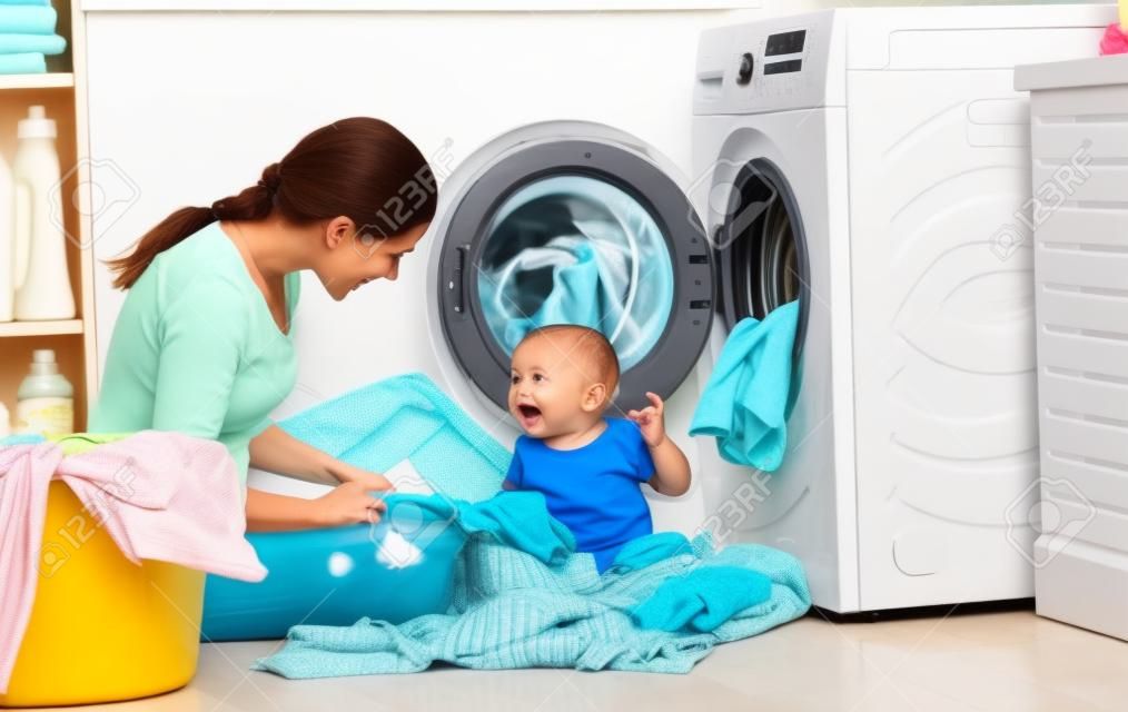 어머니 세탁에 종사하는 아기와 주부는 세탁기에 옷을 접어