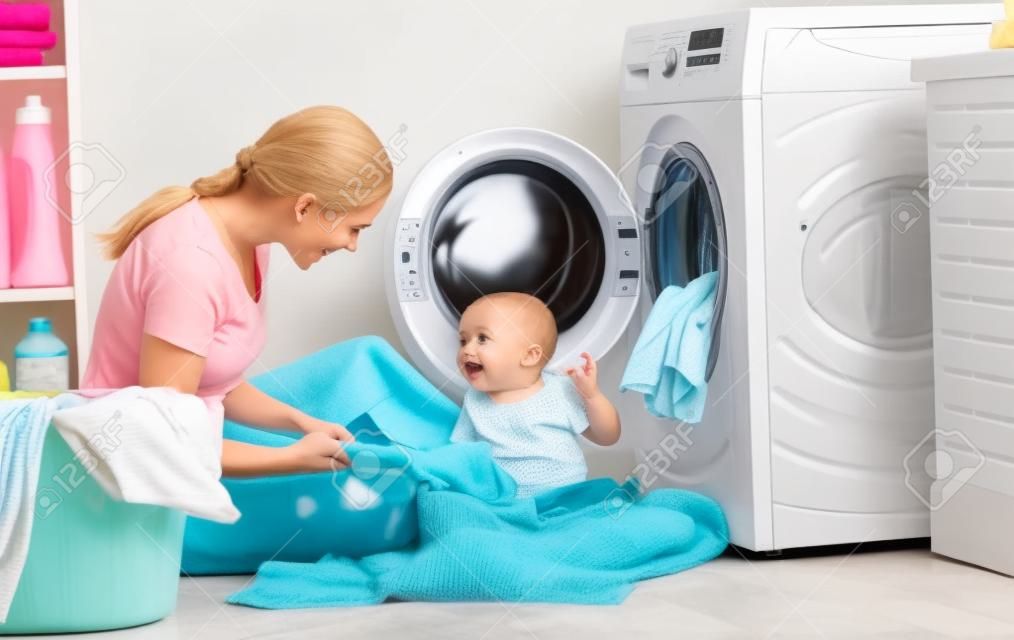 madre una casalinga con un bambino impegnato in lavanderia piegare i vestiti nella lavatrice