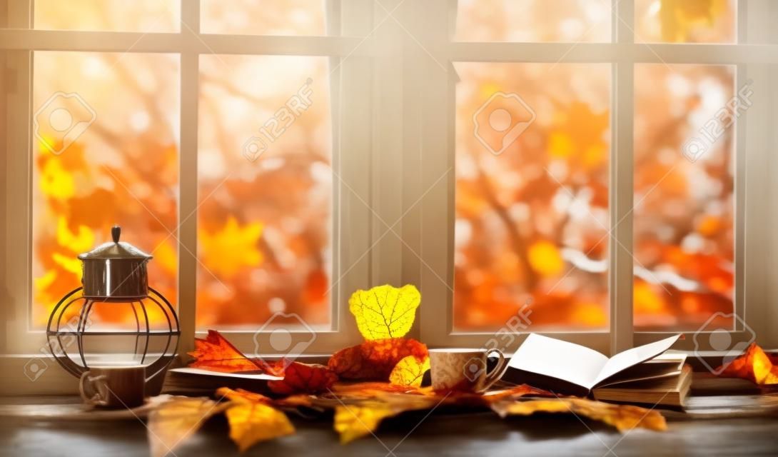 herfst. gezellig raam met herfst bladeren, een boek, een kopje thee