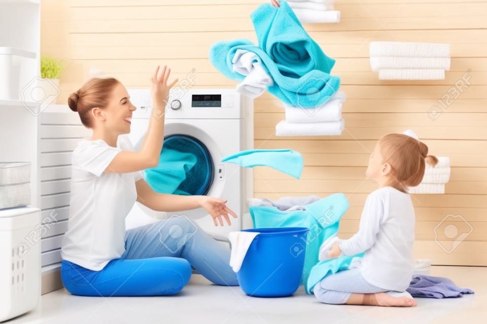 Glückliche Familie Mutter Hausfrau und Kind Tochter in Wäsche mit Waschmaschine
