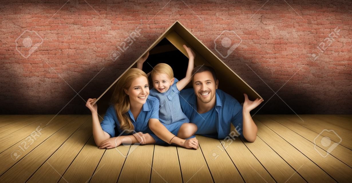 concept housing a young family. Mother father and child in new house with a roof at empty brick wall
