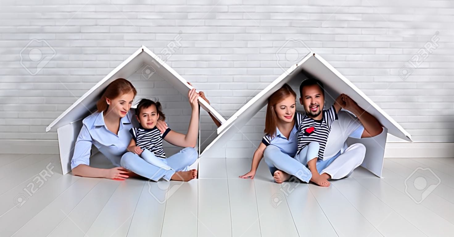 koncepcja mieszkania młodej rodziny. Matka, ojciec i dziecko w nowym domu z dachem przy pustym murem