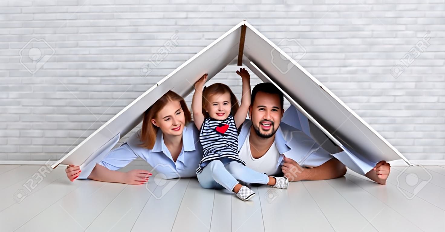 一个年轻的家庭的概念。父亲和孩子的母亲在空房子里的屋顶的新房子