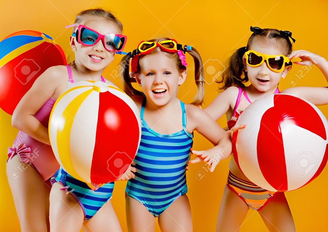 смешные смешные счастливые дети прыгают в купальниках и плавательных очках прыгают на цветном фоне