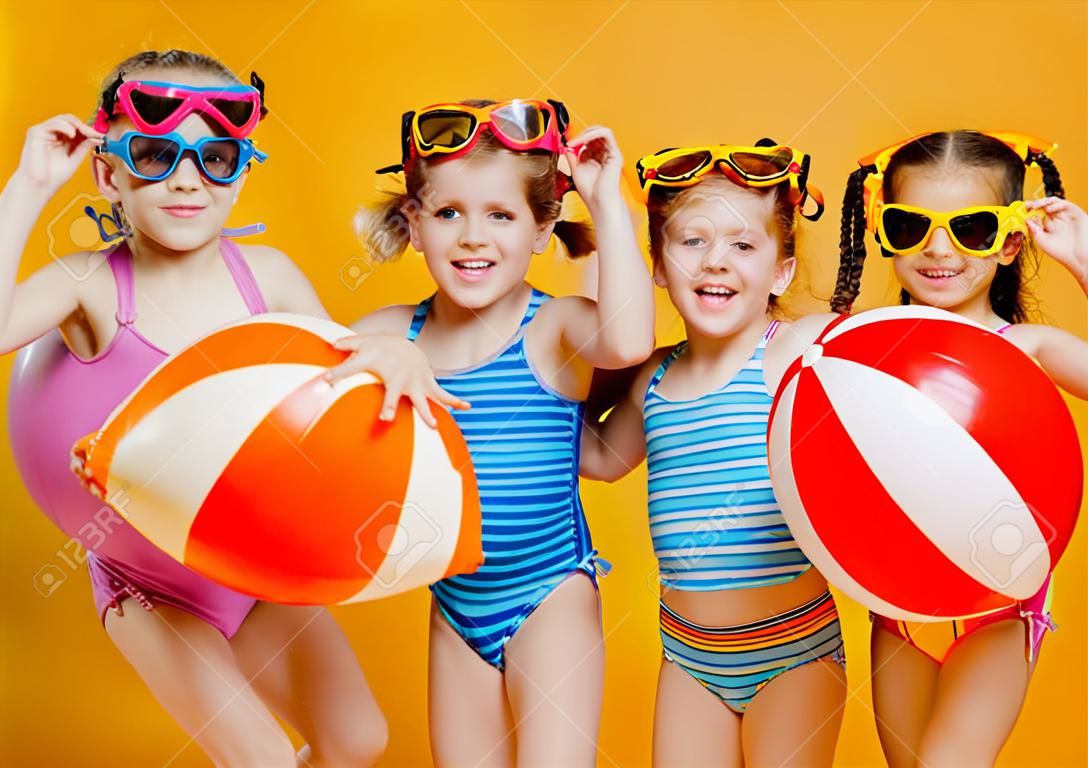 有趣的有趣快樂的孩子們跳進泳裝和游泳眼鏡跳上彩色背景