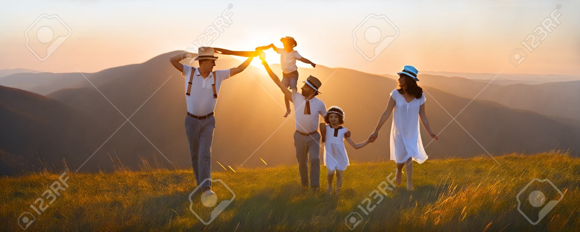 Mutlu aile: anne, baba, çocuk, oğul ve kız, doğa üzerinde günbatımı üzerinde