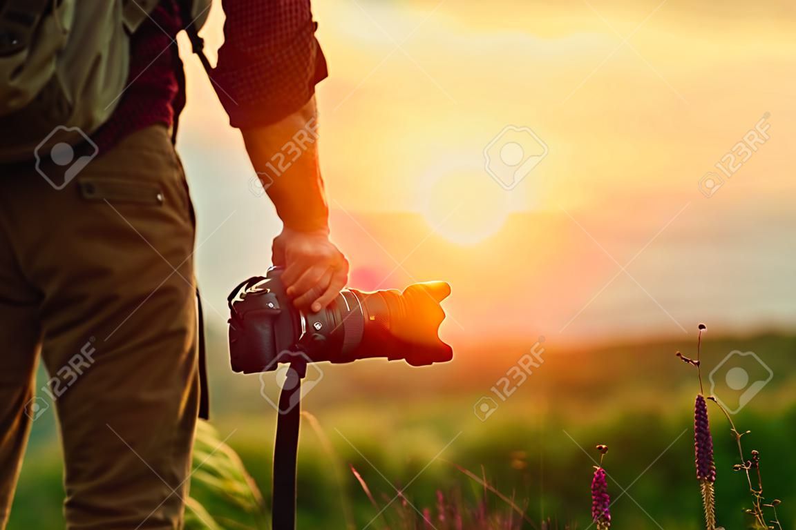 reisfotograaf. man reiziger met camera in bergen bij zonsondergang in de natuur