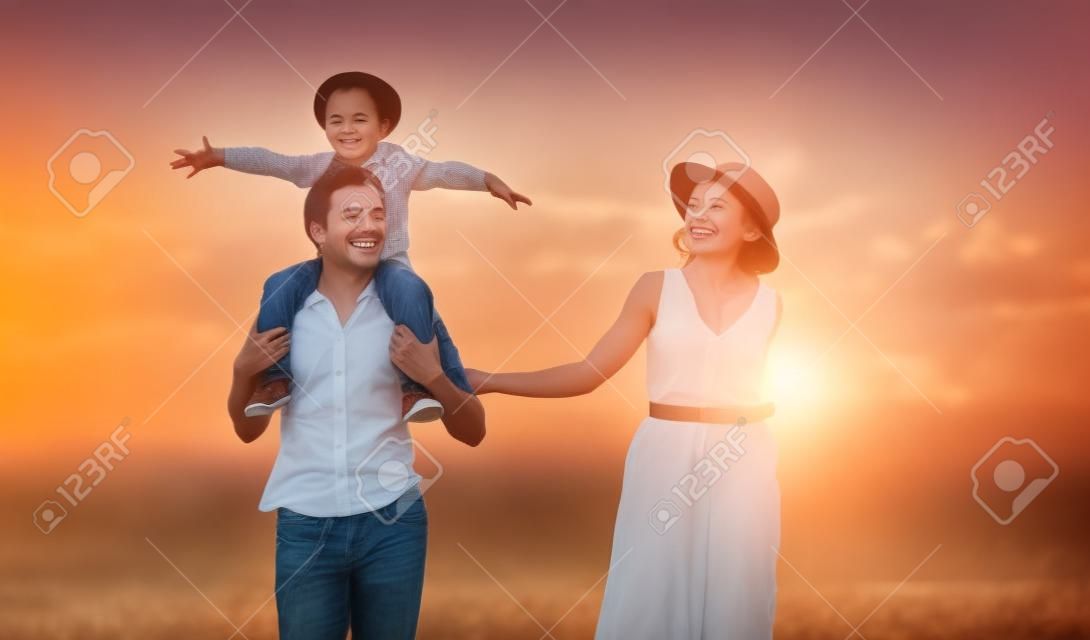 Feliz pai de família de mãe e filho na natureza ao pôr do sol