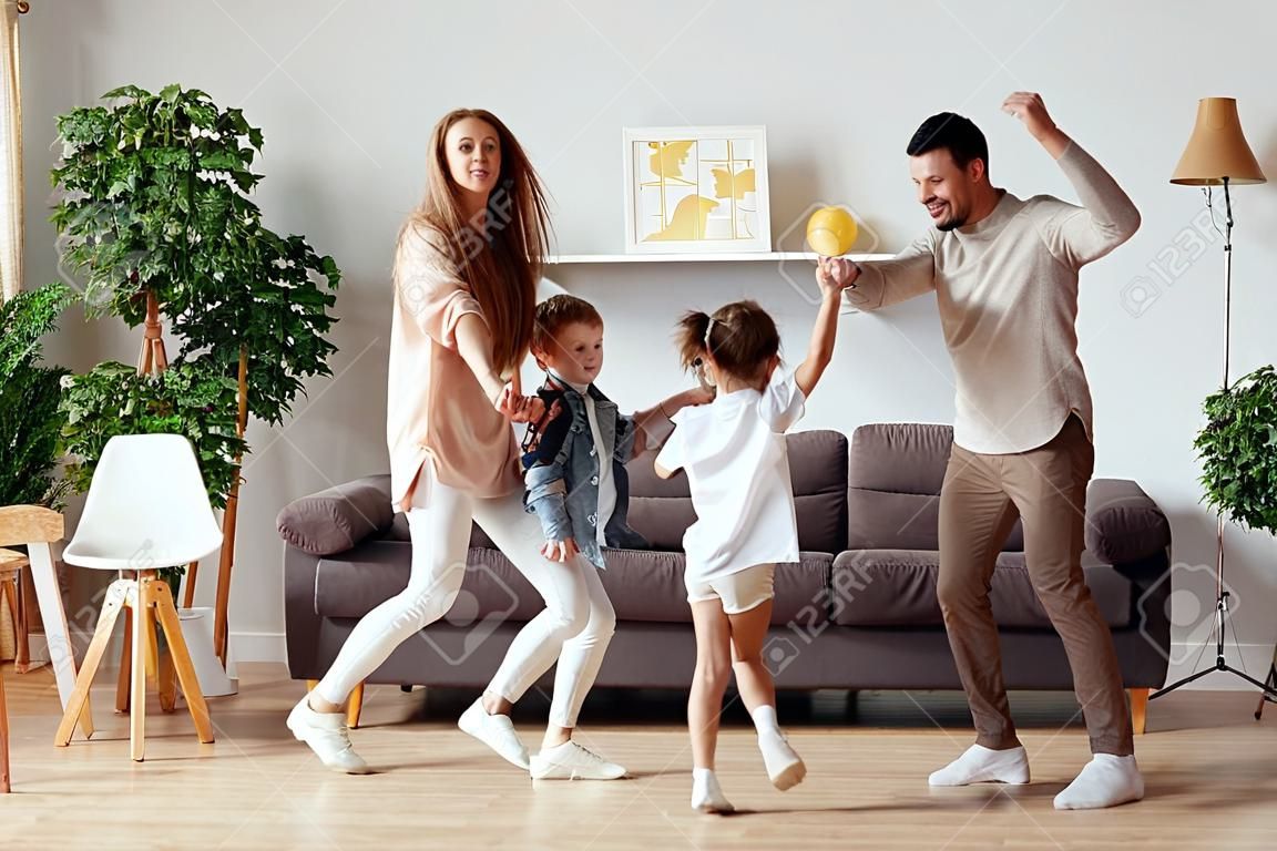 행복한 가족 어머니 아버지와 아이들 딸과 아들이 춤을 추고 집에서 즐거운 시간을 보내고 있습니다.