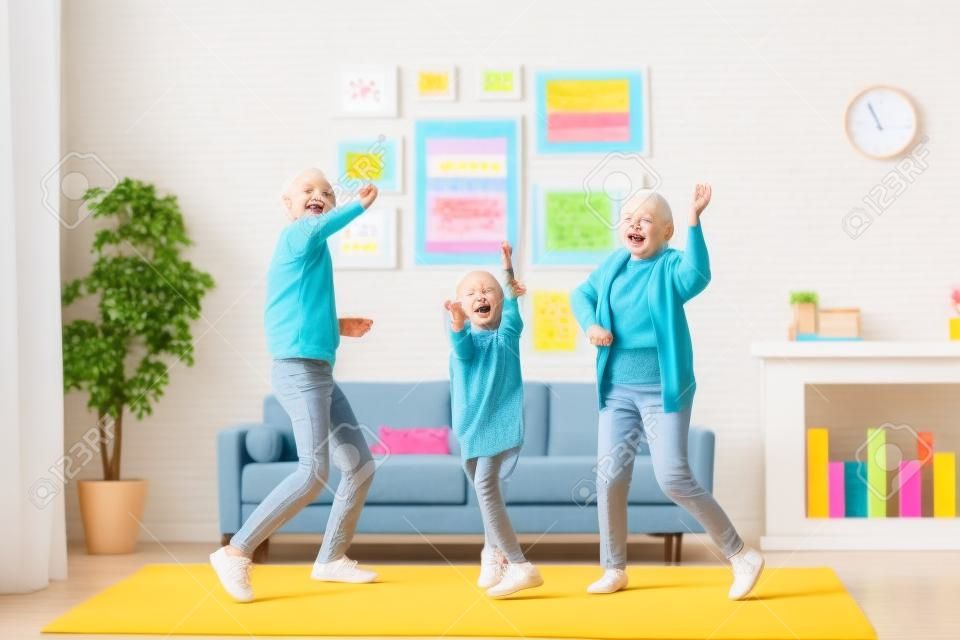 Full length of excited little preschool girl dancing having fun with active and positive grandparents. Happy child spending weekend time with family at home. Funny leisure activities concept