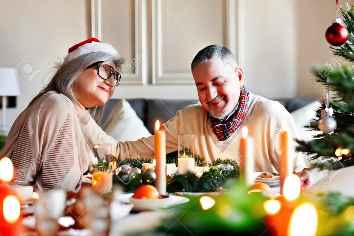 Young family couple man and woman celebrate Christmas with senior parents at home