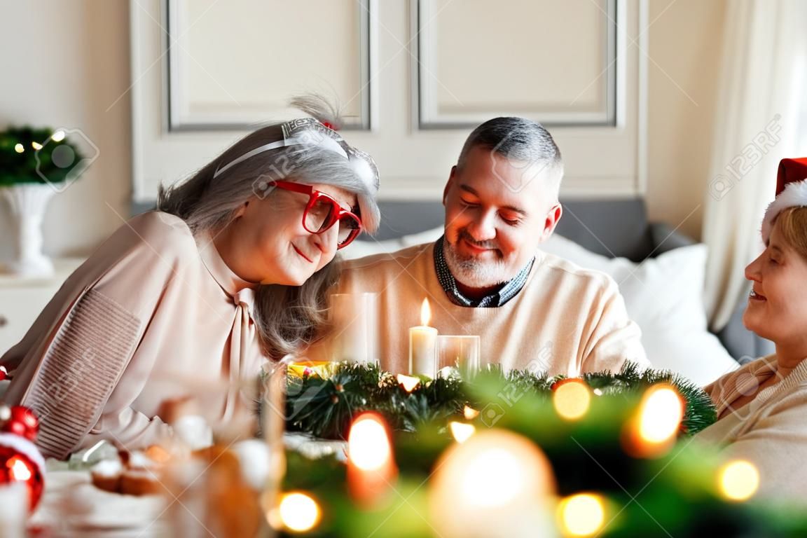 Young family couple man and woman celebrate Christmas with senior parents at home