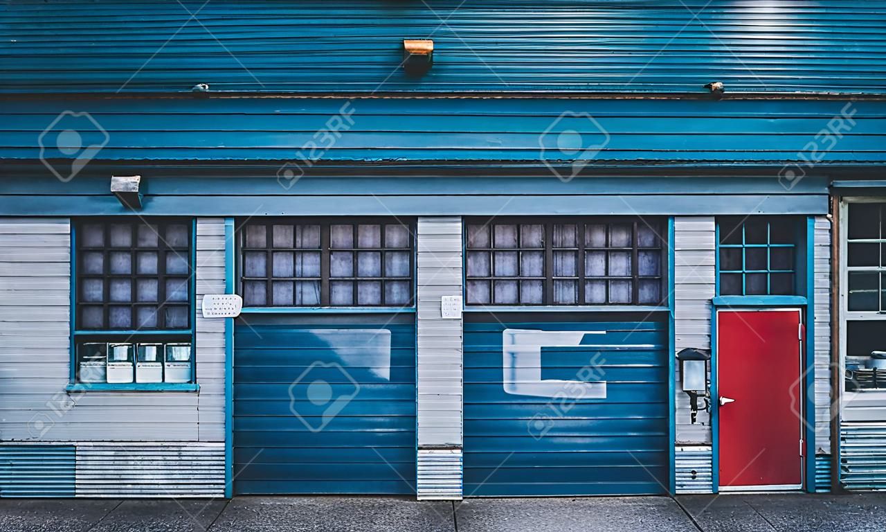 Antique old garage mechanic shop storefront with doors and windows