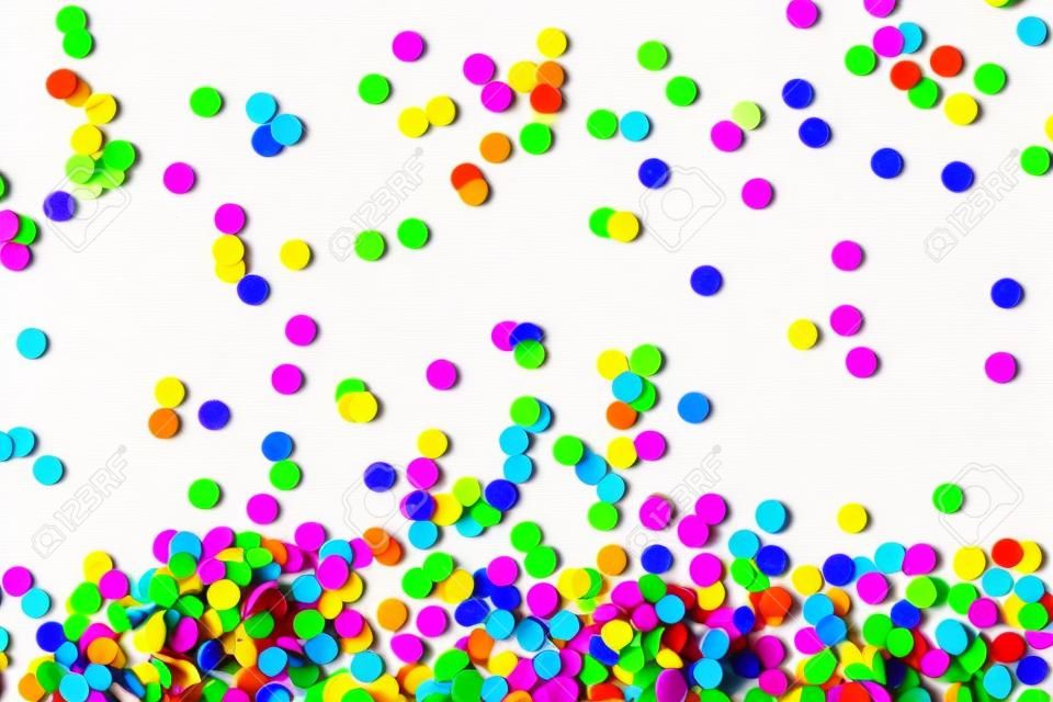 Confettis multicolores lumineux isolés sur fond blanc. Notion de fête. Fête d'enfants, anniversaire, mariage, célébration. Vue de dessus. Copiez l'espace.