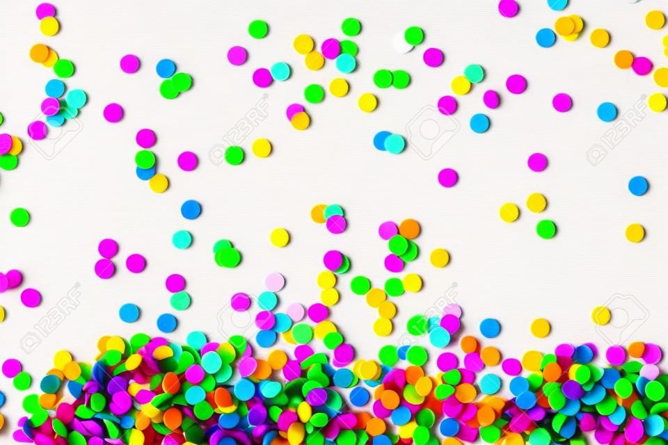 Bright multicolored confetti isolated on a white background. Festive concept. Childrens party, birthday, wedding, celebration. Top view. Copy space.