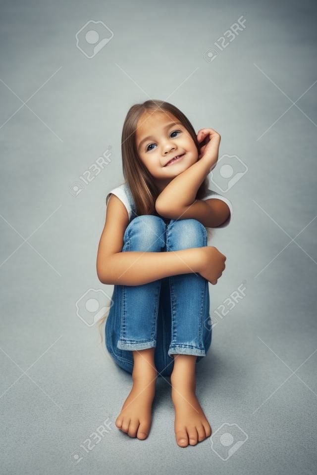 청바지에 바닥에 앉아 예쁜 소녀의 근접 촬영 이미지