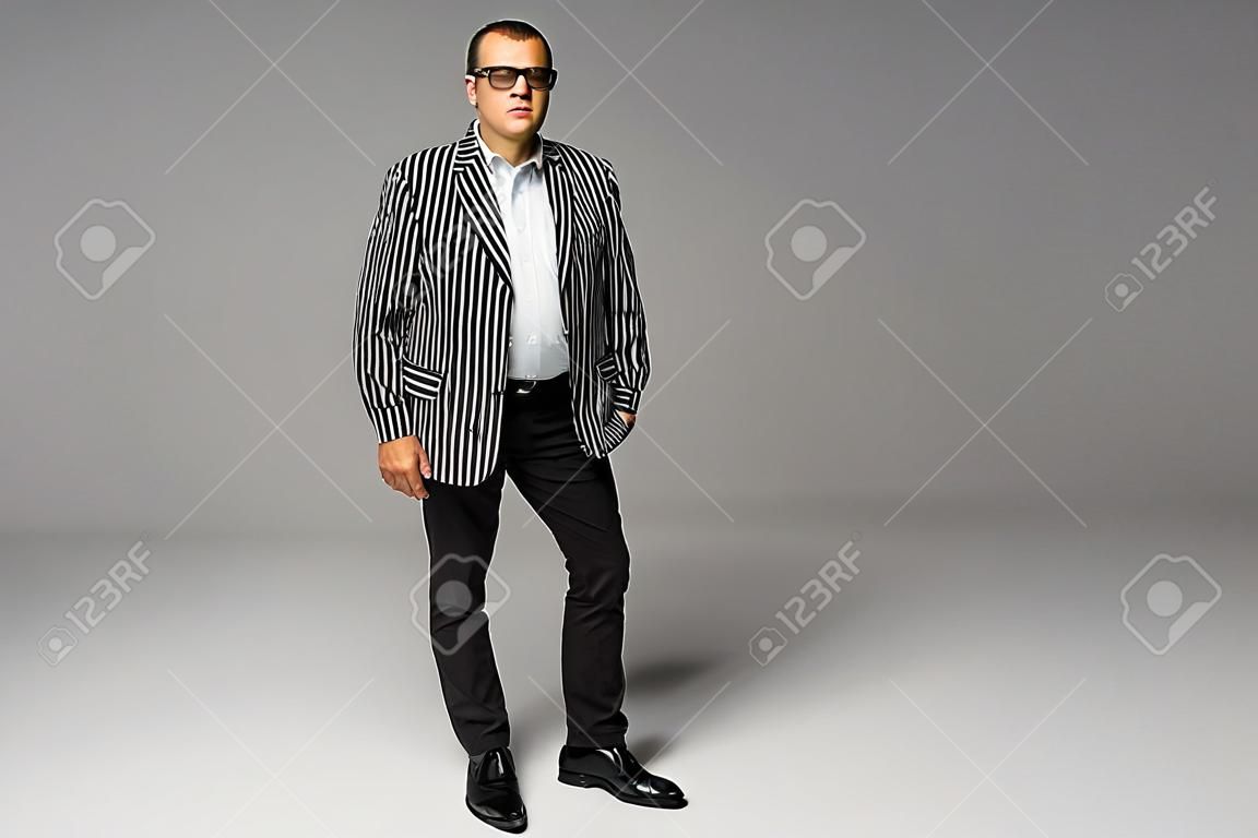Portrait of a senior older business man standing wearing dark sunglasses on white background