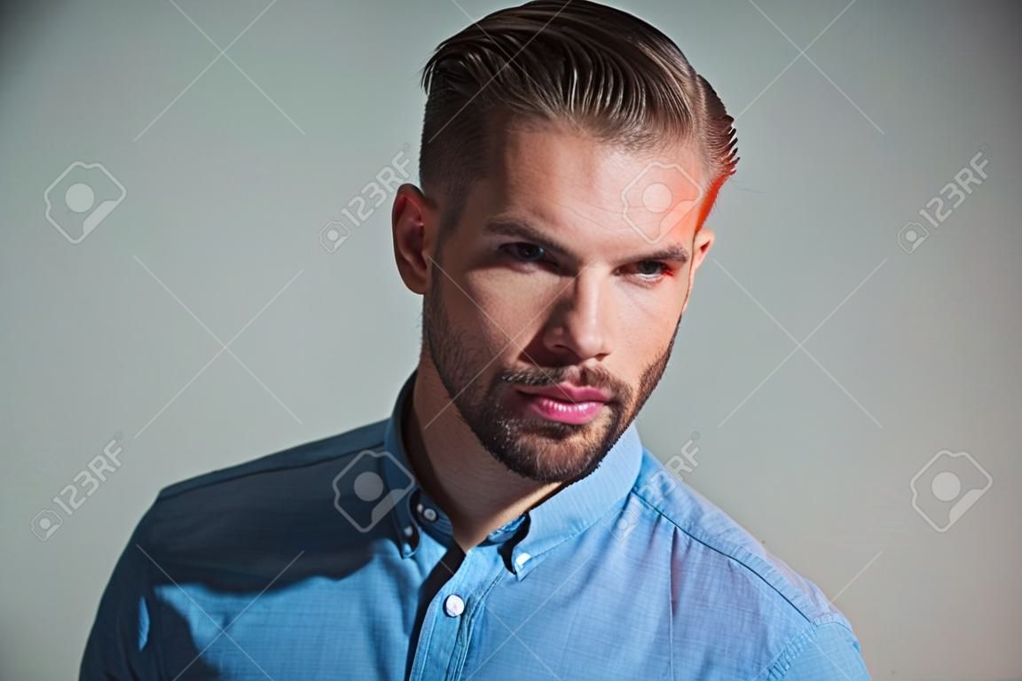 Pewny siebie udany męski model w niebieskiej koszuli. zamyślony inteligentny poważny biznesmen. atrakcyjny przystojny mężczyzna z brodą i wąsami. moda portret mężczyzny z poważną twarzą. zamyślony facet. wyraz twarzy