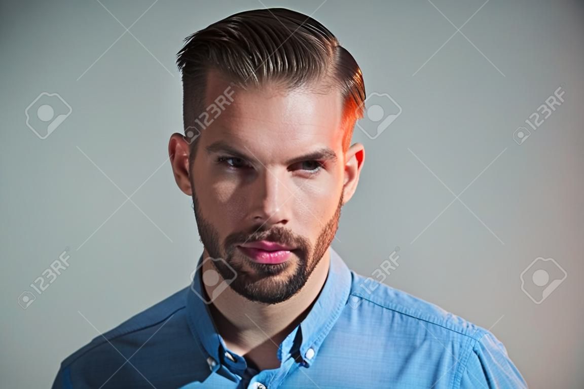 Pewny siebie udany męski model w niebieskiej koszuli. zamyślony inteligentny poważny biznesmen. atrakcyjny przystojny mężczyzna z brodą i wąsami. moda portret mężczyzny z poważną twarzą. zamyślony facet. wyraz twarzy