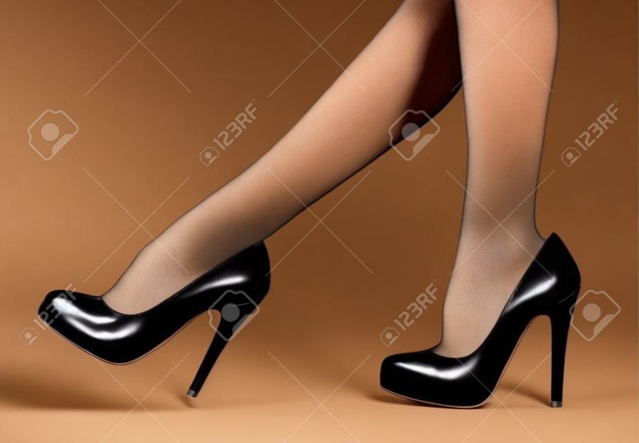 Mujer s piernas en pantimedias finas y tacones altos
