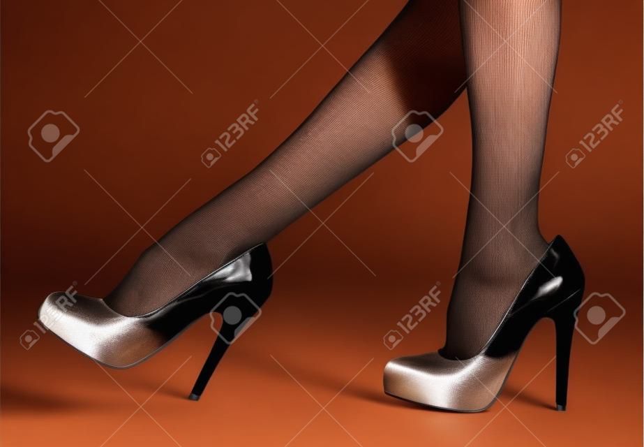 Mujer s piernas en pantimedias finas y tacones altos
