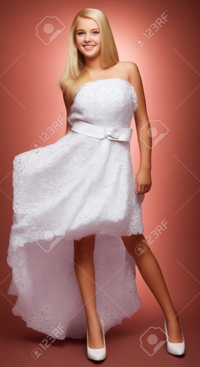 Muchacha adolescente rubia en un vestido y tacones