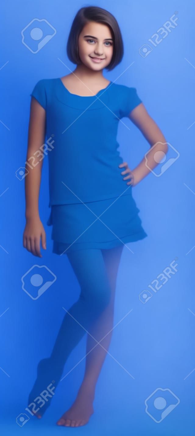 Mignon Teen Girl posant sur un fond de studio Bleu