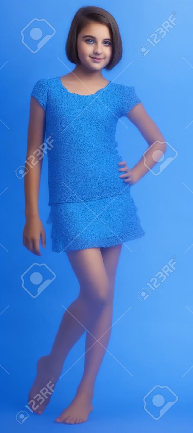 Adolescente linda chica posando sobre un fondo azul Studio