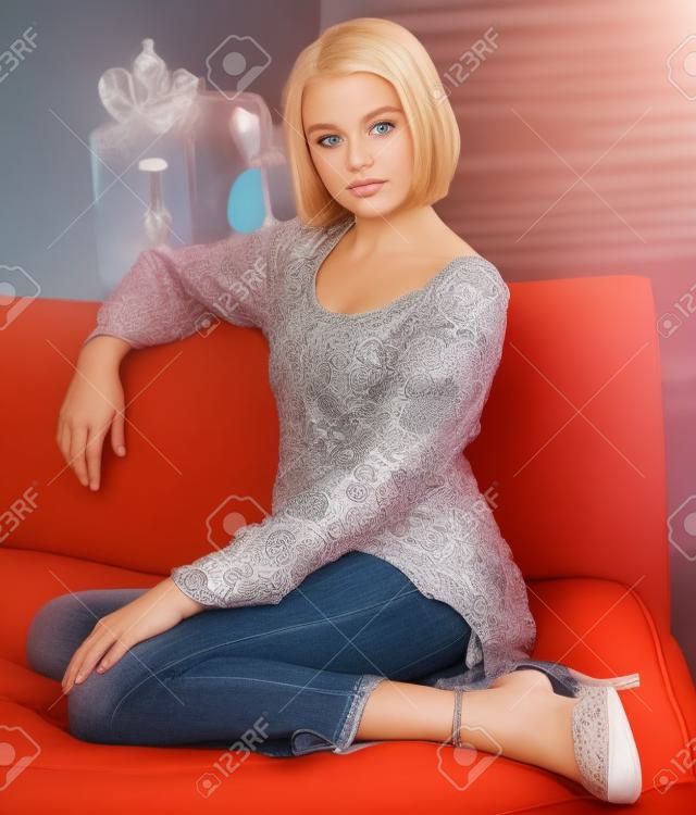 L'adolescence blonde GirlPosing sur le divan