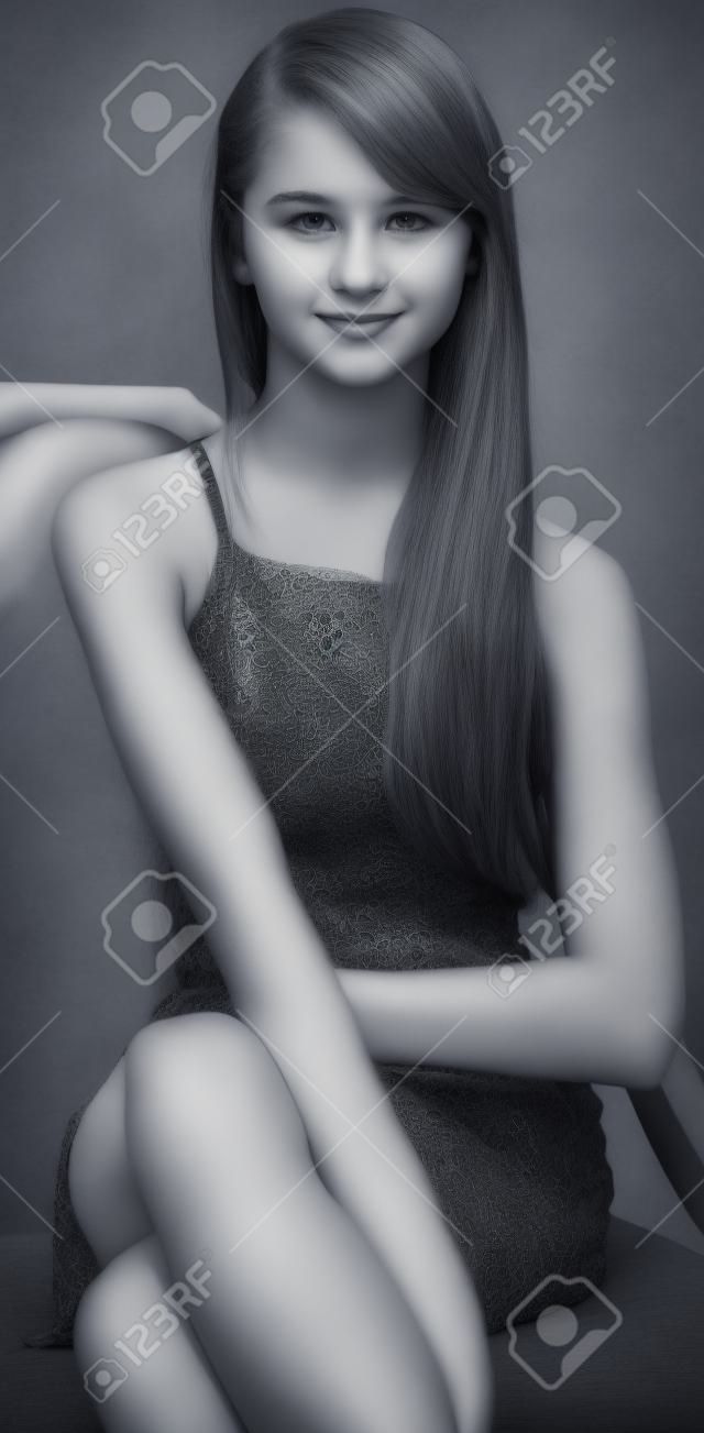 灰色の服で座っている十代の少女