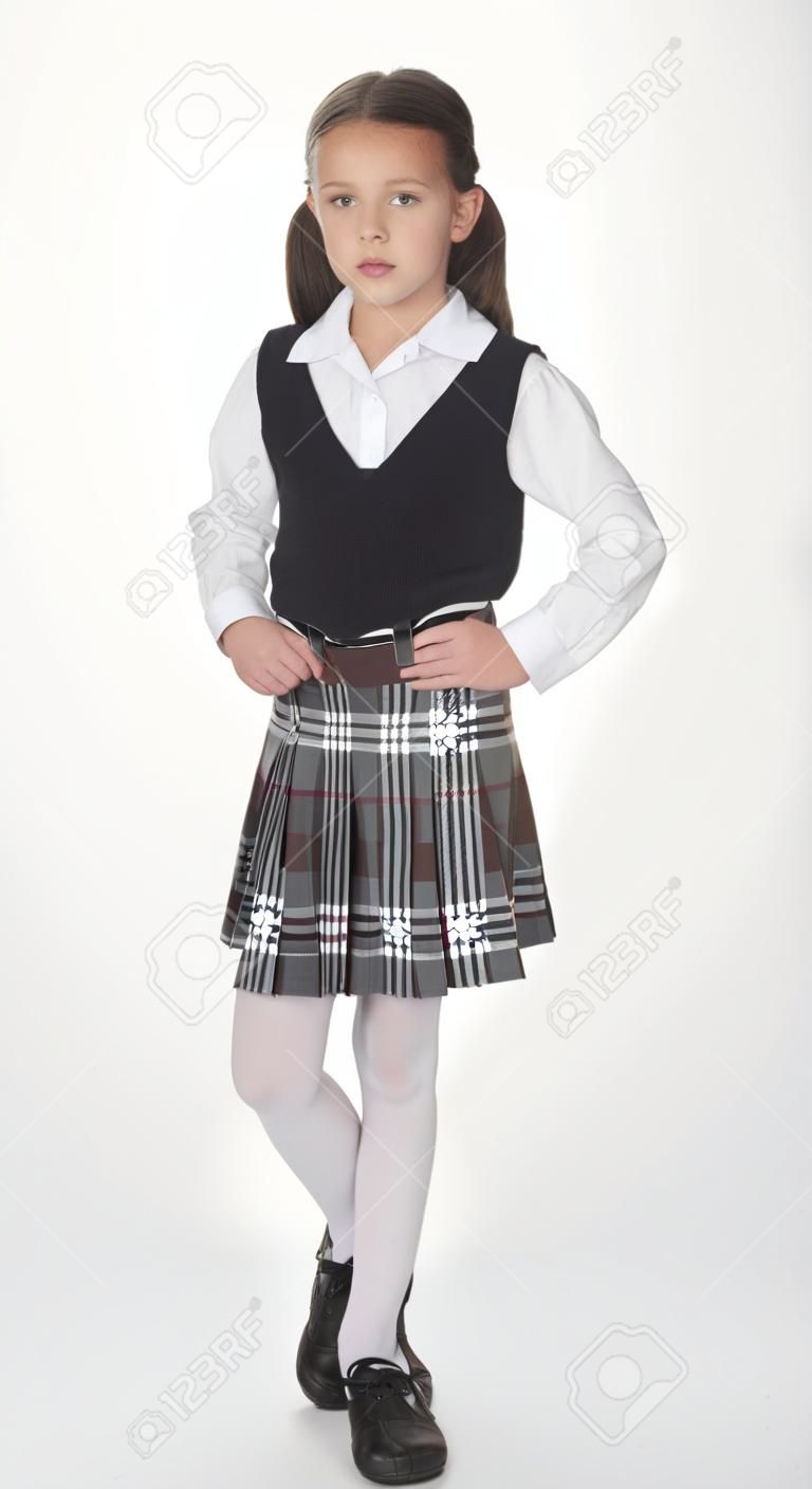 Muchacha de la escuela católica que presenta en uniforme escolar