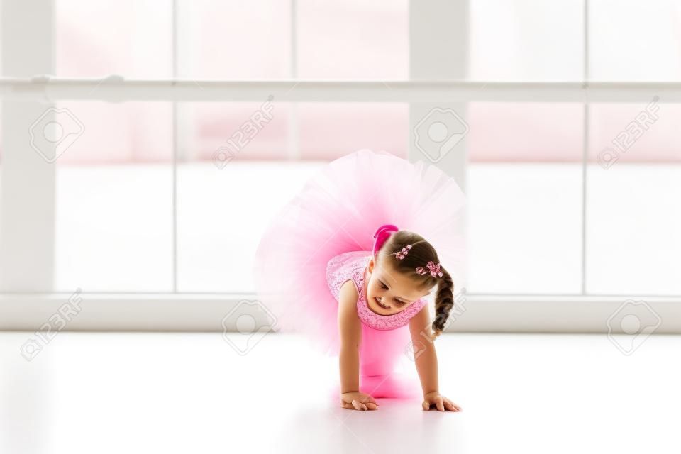 핑크 투투에서 어린 발레리나 소녀. 흰색 스튜디오에서 고전 발레 춤 사랑스러운 아이입니다. 아이들은 춤. 아이들은 수행. 클래스의 젊은 재능있는 댄서. 미술 수업을 복용 유치원 아이.