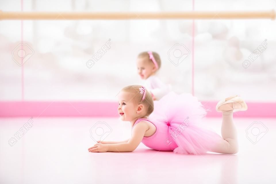 Kleine Ballerina Mädchen in einem rosa Tutu. Entzückendes Kind tanzt klassisches Ballett in einem weißen Studio. Kinder tanzen. Kids Durchführung. Junge begnadeter Tänzer in einer Klasse. Vorschulkind nehmen Kunstunterricht.